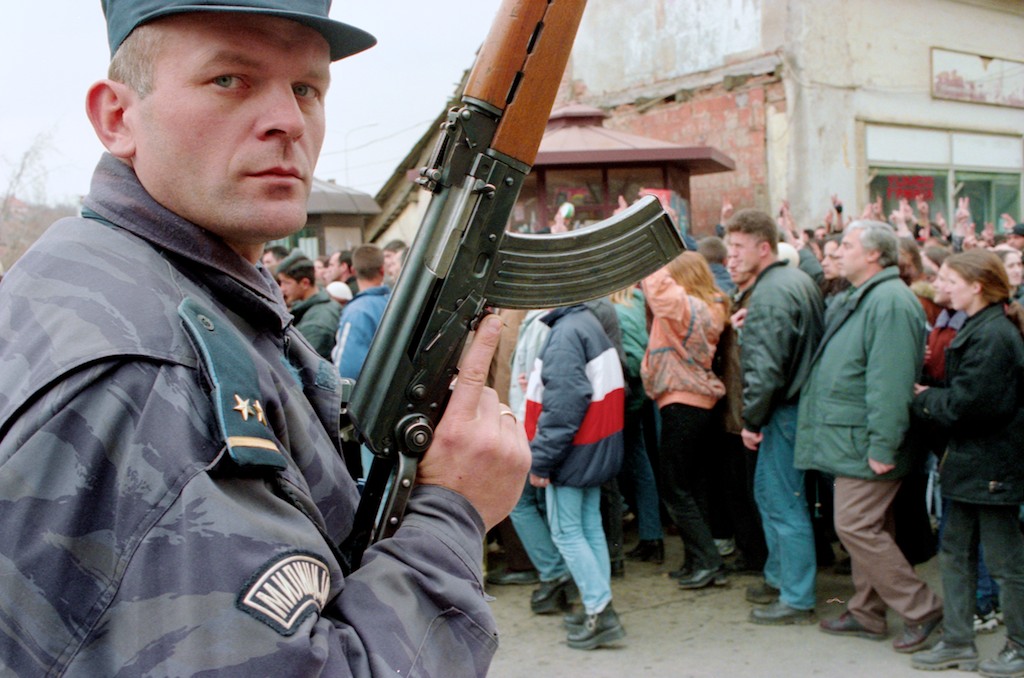Serbian policeman with Kalashnikov - Kosovo, Pristina: a Serbian policeman watches over an Albanian protest in Pristina.