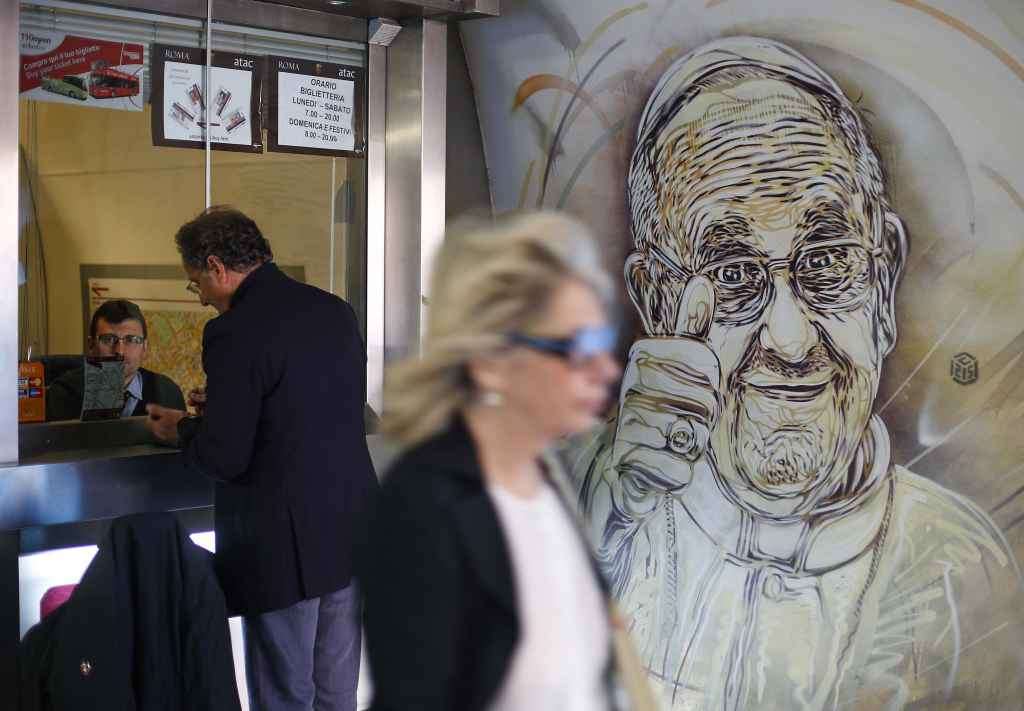 A mural by French street artist Christian Guemy, also known as C215, which depicts Pope Francis giving the thumbs-up sign, is seen in a subway station in downtown Rome